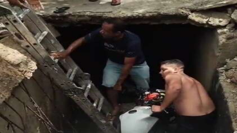 Vídeo: Motociclista e crianças caem em buraco após tampa de galeria se romper